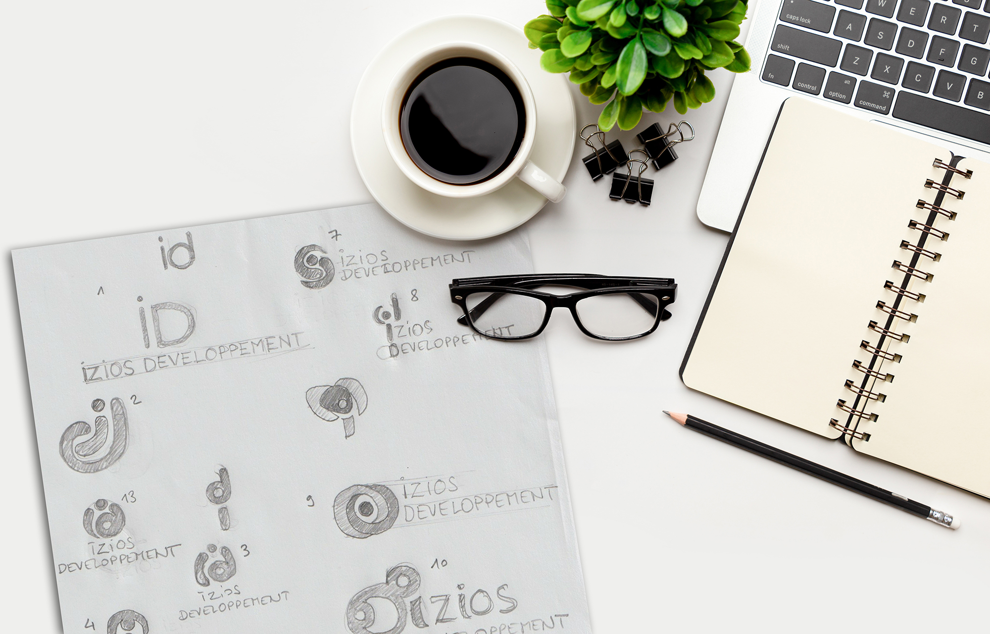 Flat lay, top view office table desk. Workspace with blank Laptop, office supplies, pencil, green leaf, and coffee cup on white background.